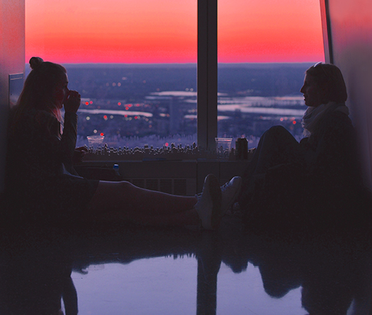 Two young women in conversation with sunset reflecting theme Opportunities that Change Lives at McGill