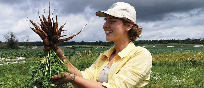 Kayla Dowd holding a bunch of carrots