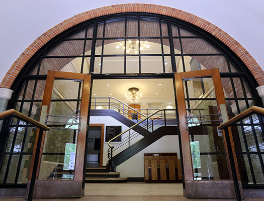 Une grande porte vitrée avec un escalier menant à l'entrée