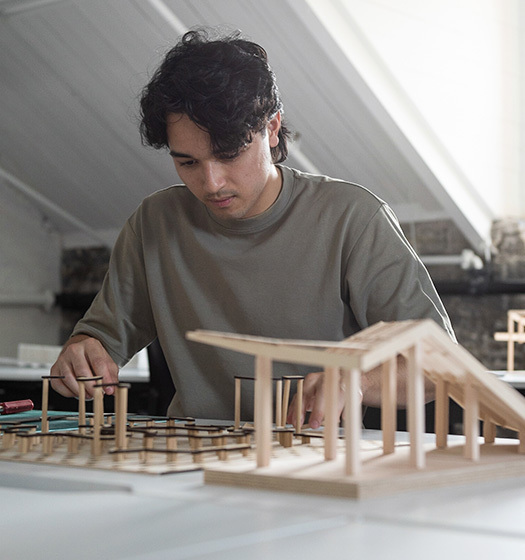 Une personne travaillant sur la maquette d'un bâtiment