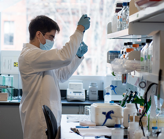 Un homme portant un masque et des gants dans un laboratoire