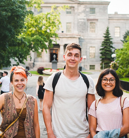 Trois étudiants debout sur l'allée devant le bâtiment McCall MacBain.