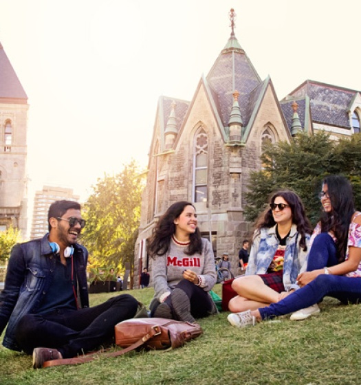 Quatre étudiants assis sur la pelouse du campus de McGill.
