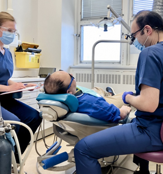 Une groupe de personnes travaillant autour d'un patient sur un fauteuil dentaire