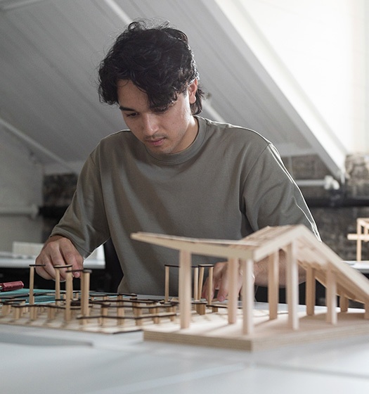Une personne travaillant sur la maquette d'un bâtiment