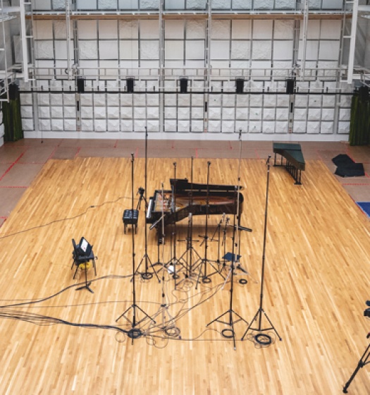 Une grande salle vide avec un piano et du matériel