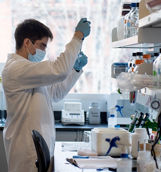 Un homme portant un masque et des gants dans un laboratoire